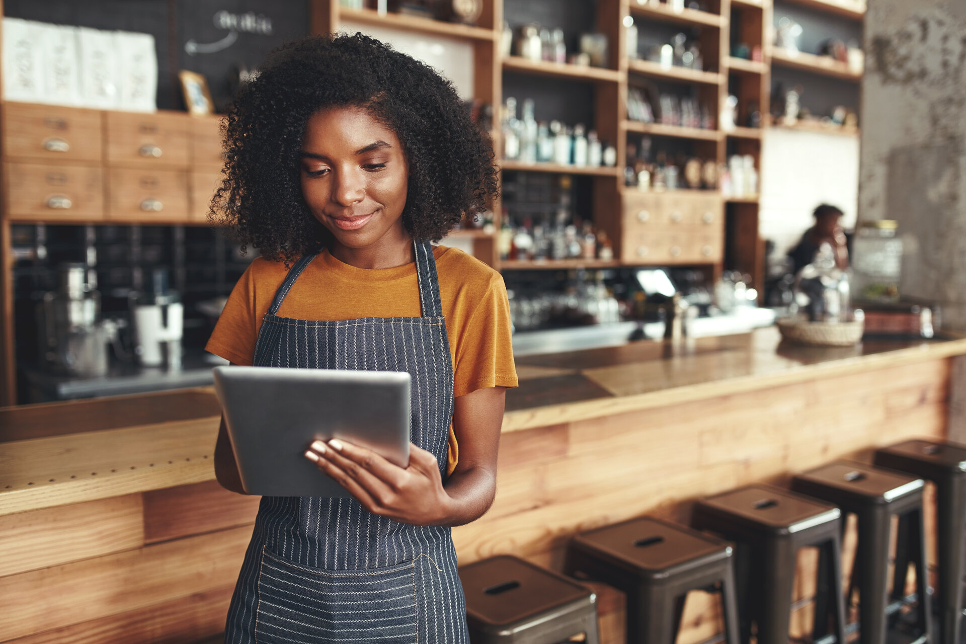 Successful small business owner using digital tablet in her cafe group coaching 3